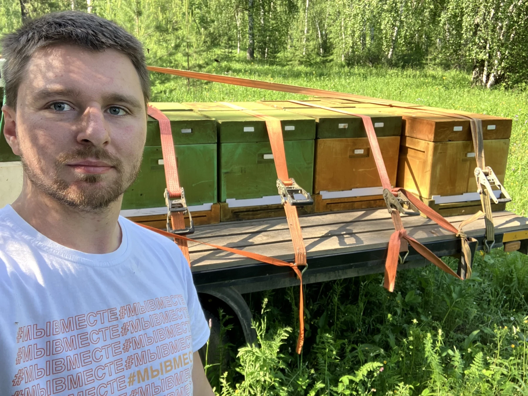 Пчеловод кооператива на пасеке рядом с ульями